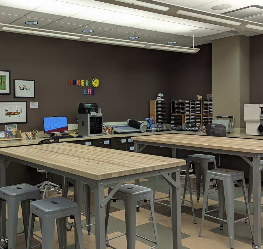 Makerspace with equipment including 3D printer, laser, Cricut Machines, and large format printer.